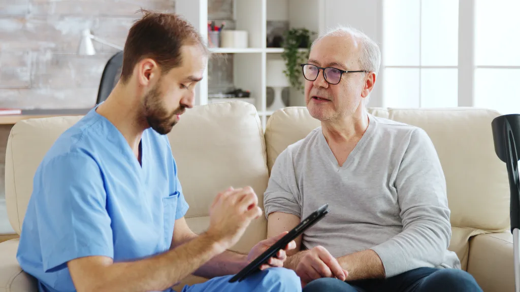 Stallio Outsourcing Comprehensive outsourcing solutions. Caucasian Male Nurse Talking With A Nursing Home Patient About His Health